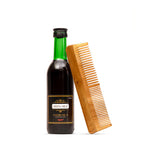 Bottle of Green Milk hair oil with a wooden comb on a white background