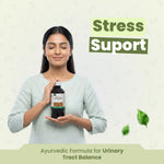 Woman holding a bottle labeled 'Stress Support' with text about an Ayurvedic formula on a light background