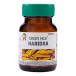 Bottle of Green Milk Haridra tablets with a green cap on a white background