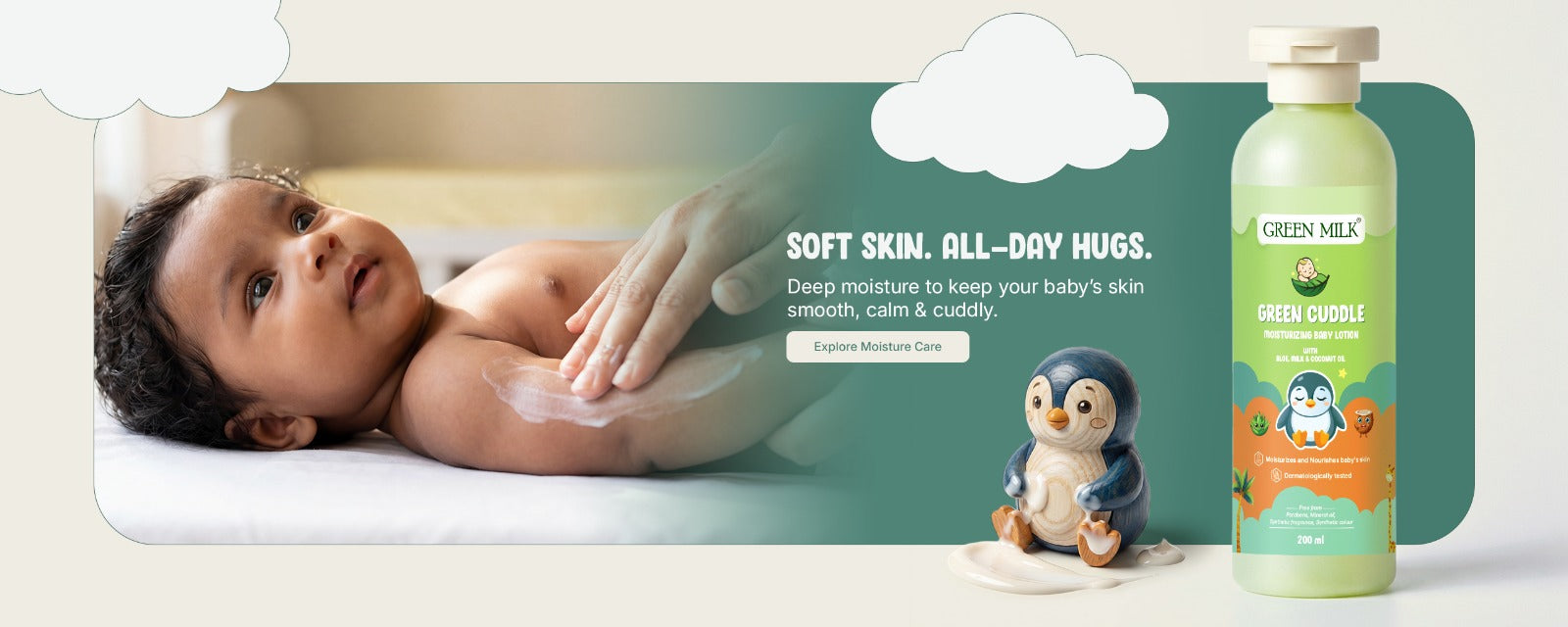 Baby lying on a white surface with a bottle of Green Mil's product and a penguin toy in the background.
