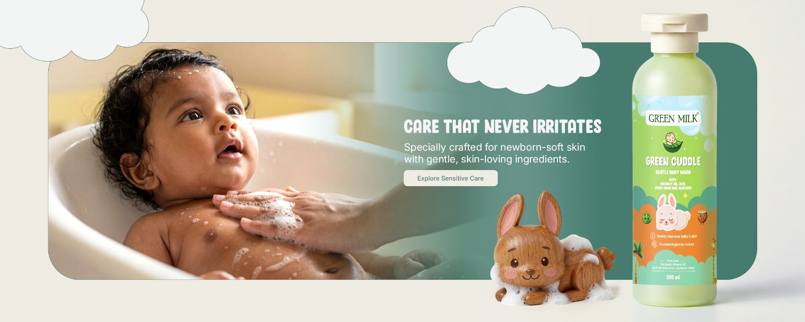 Baby being bathed with a bottle of Green Milk baby wash and a toy rabbit on a white background