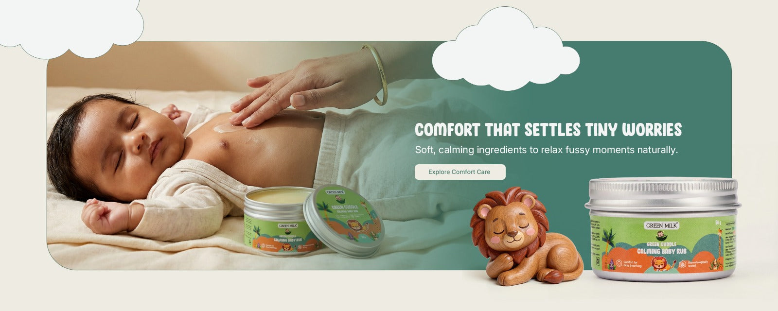 Baby lying on a blanket with a bottle and jar of cream, accompanied by a lion figurine and text about comfort.