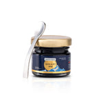 Jar of Shilajit resin with a spoon on a white background