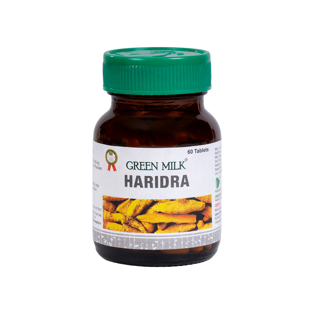 Bottle of Green Milk Haridra tablets with a green cap on a white background