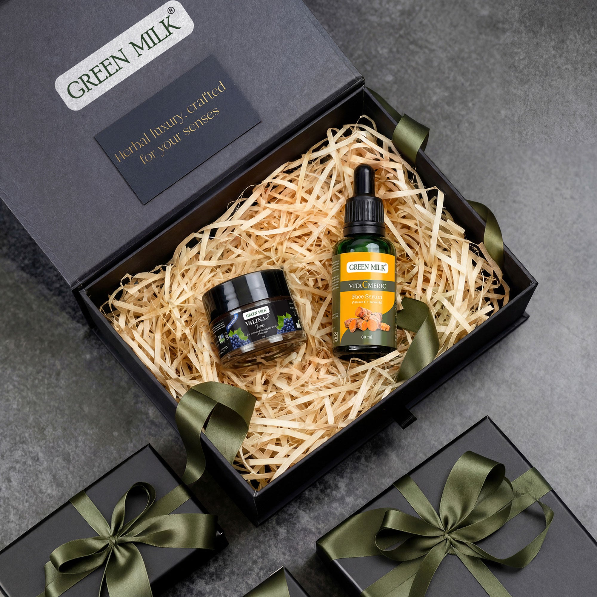 Green Milk skincare product set in a gift box with decorative ribbons on a gray background