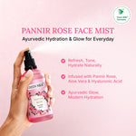 Hand holding a bottle of Green Milk Pannir Rose Face Mist on a pink background